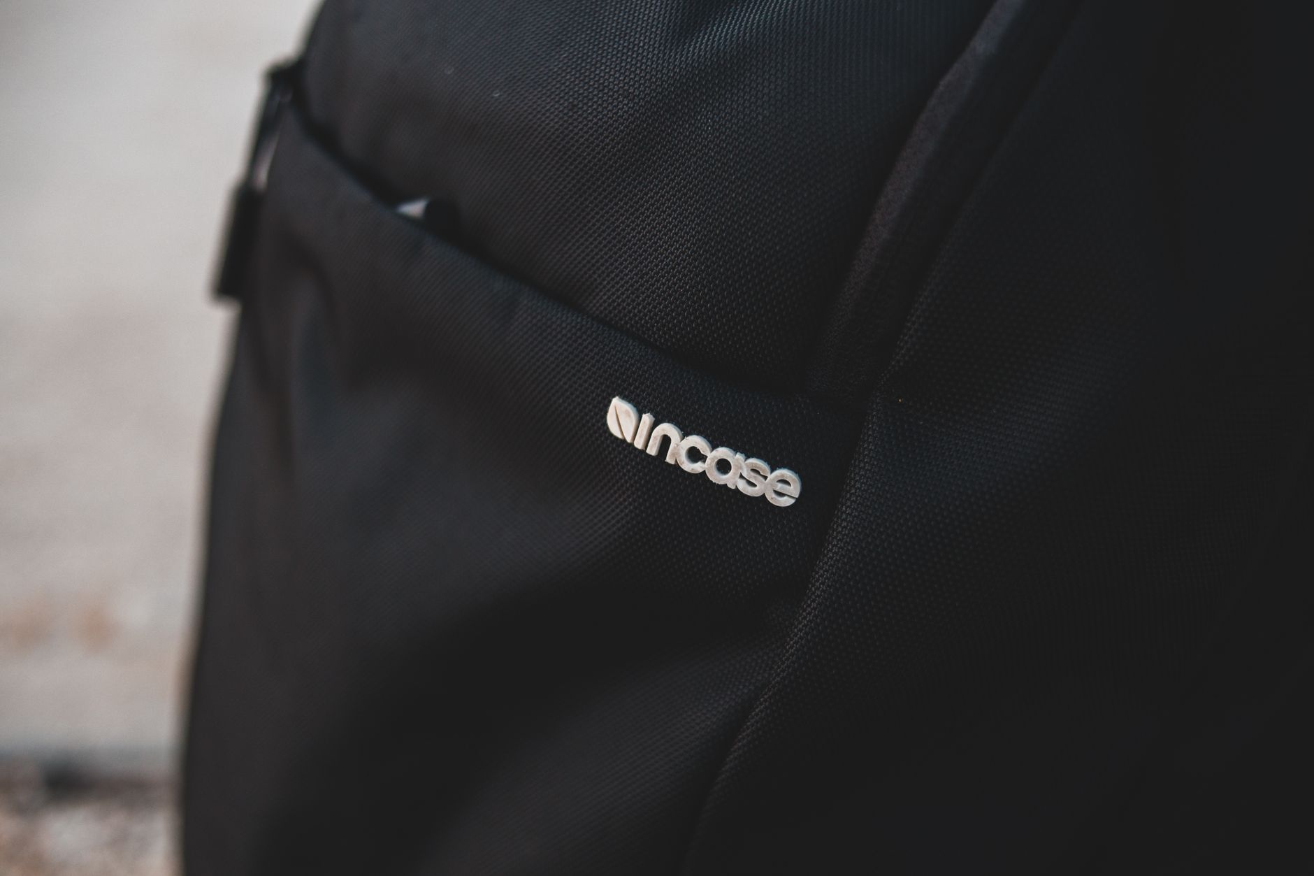 Minimalist close-up of a black backpack featuring incase branding, perfect for travel and style.