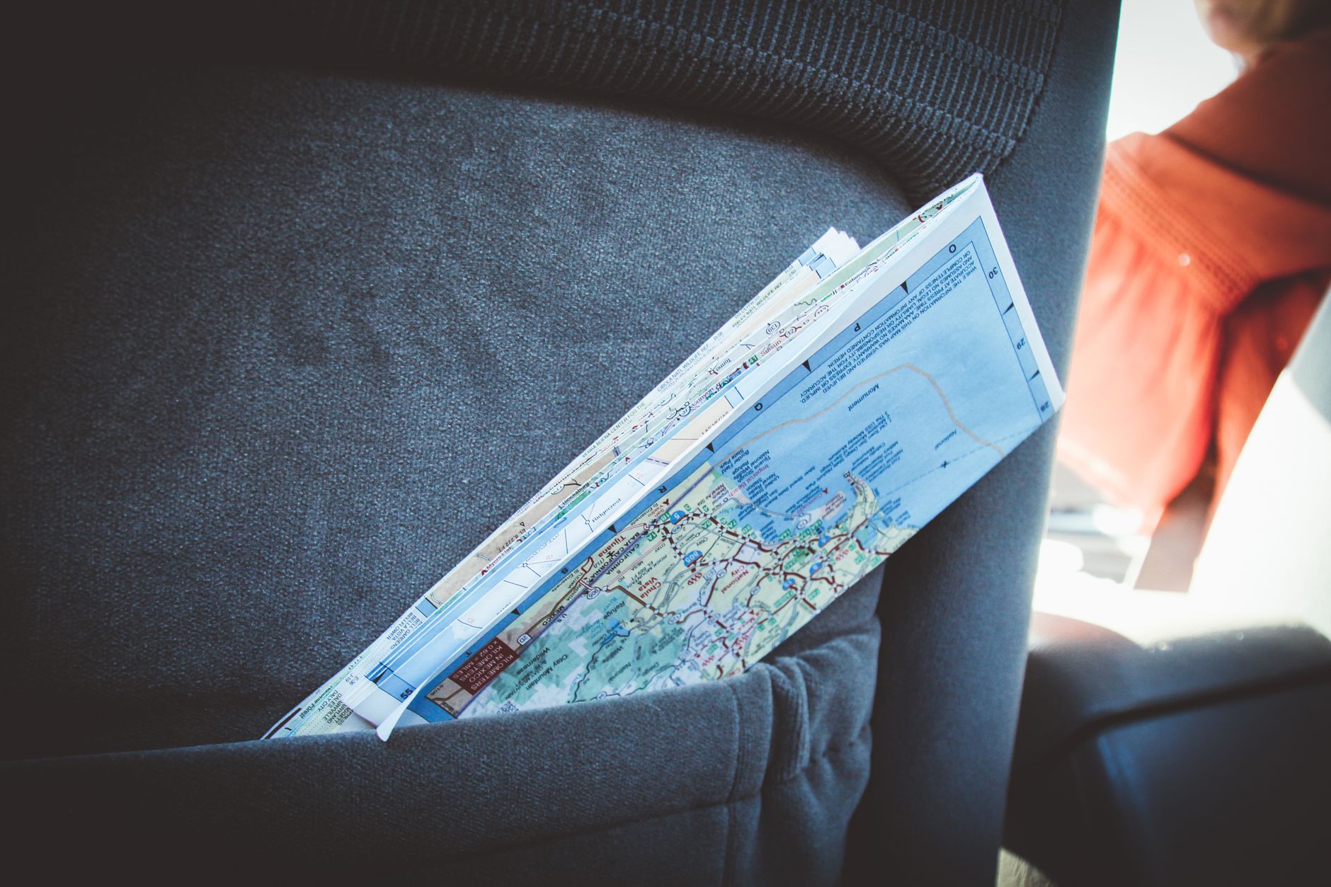 A folded map in a car seat pocket, perfect for planning a road trip.