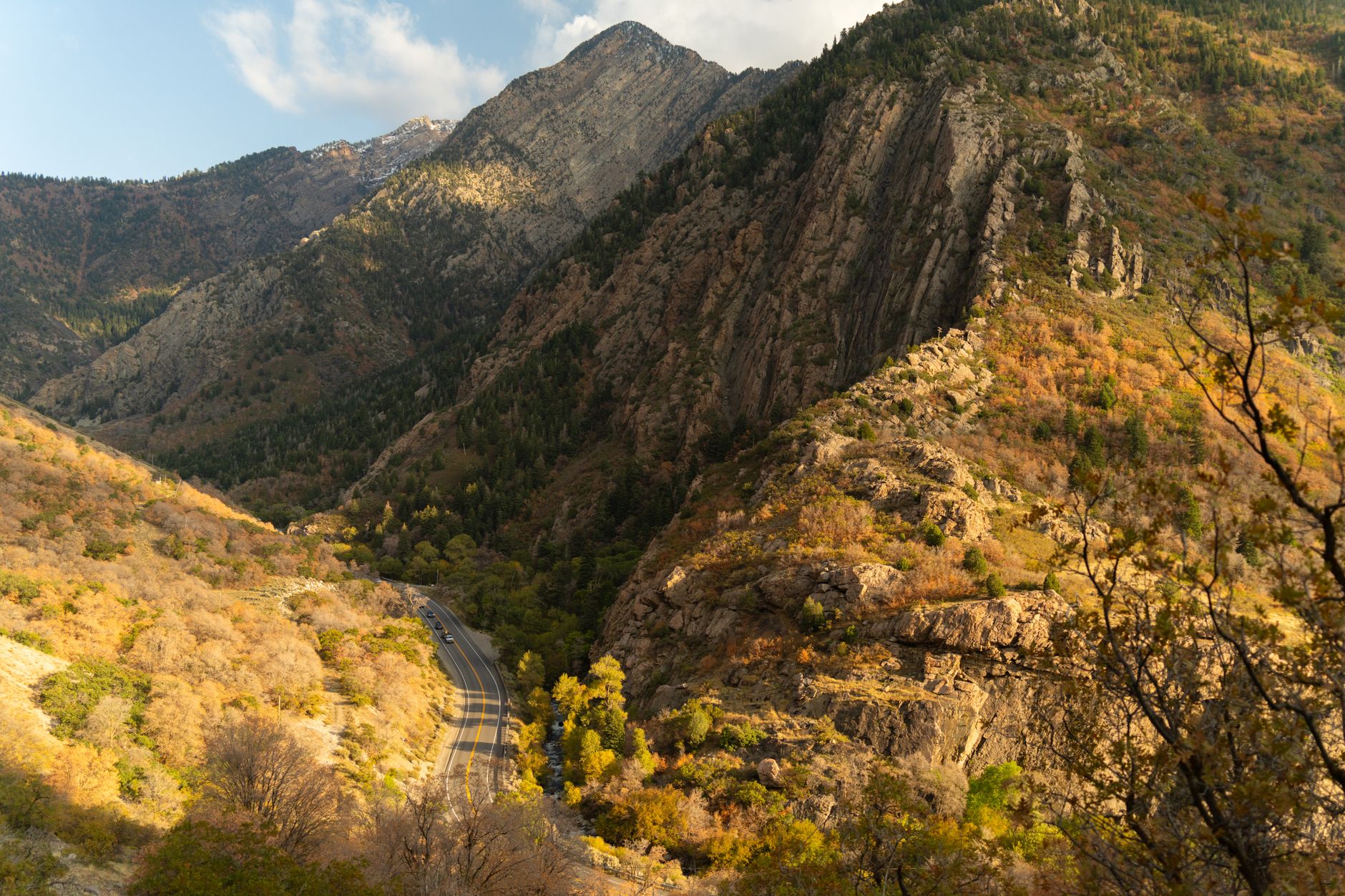 A breathtaking view of Big Cottonwood Canyon in autumn with colorful foliage and a winding road.