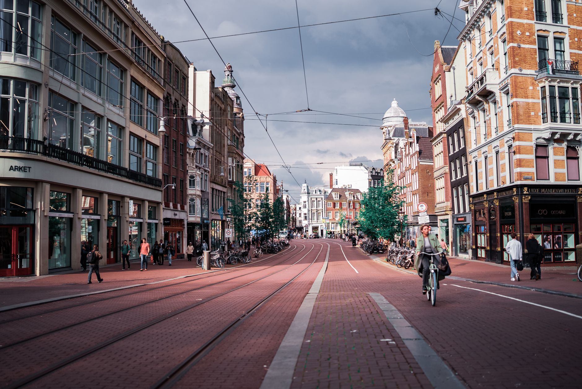 A scenic street view in Amsterdam showcasing the vibrant architecture and a cyclist on a clear day.